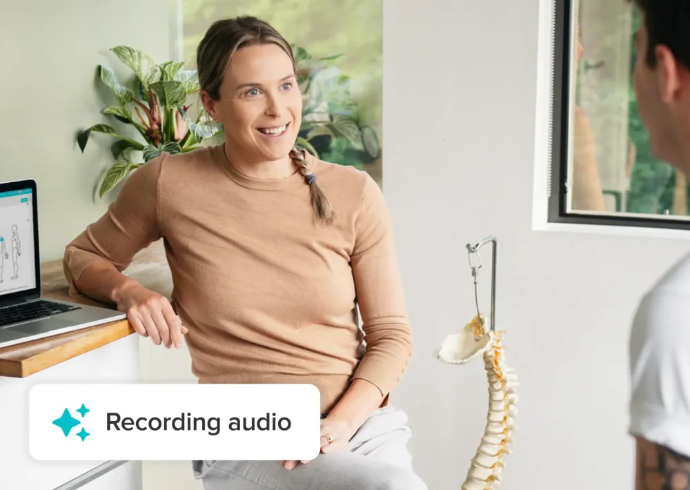 Chiropractor speaking with a patient during an in-clinic consultation while Jane AI Scribe records audio on a laptop.