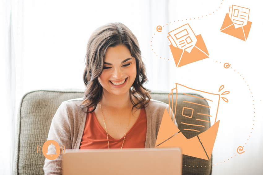 Kendall Hagensen, clinic owner, mental health practitioner, and business coach smiles at her laptop as illustrations of notification bells and opened mail float from the screen