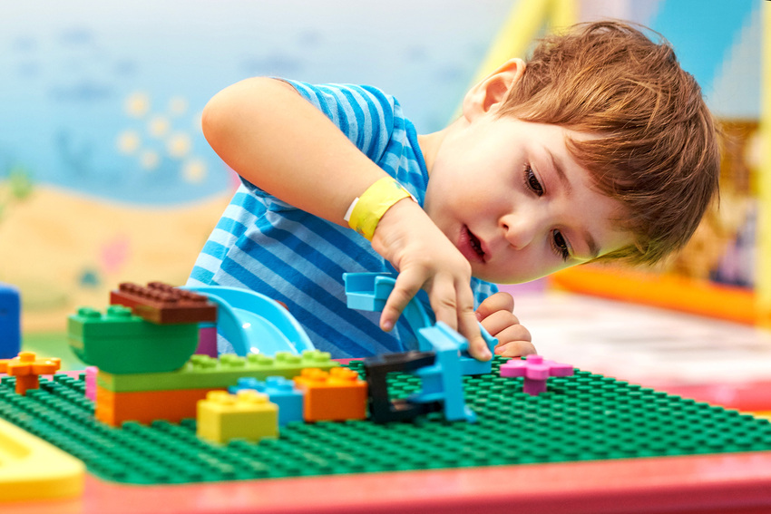 Young boy builds a lego set in a waiting room