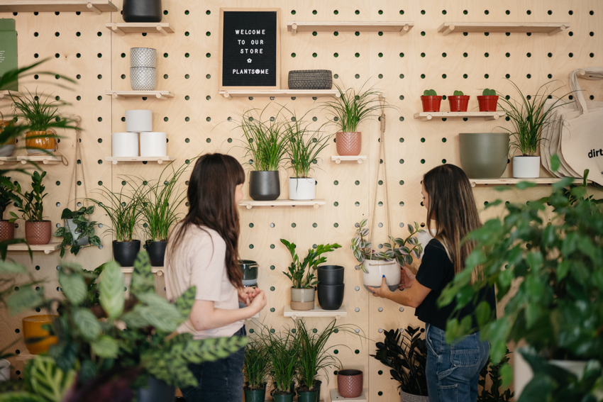 Rachel Burns, author of this article, stands in front of a plant option and speaks with someone at Plantsome about her options